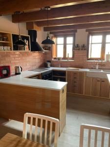 uma grande cozinha com armários de madeira e uma bancada em Ca La Gràcia em Cabrianas