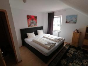 a bedroom with a bed with white sheets and a window at Zimmer in Kaiserslautern in Kaiserslautern