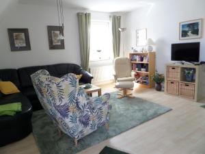a living room with a couch and a chair at Birkenstraße 15b Whg 13 in Zingst
