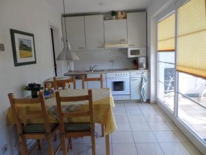 a kitchen with a table and chairs and a kitchen with white cabinets at Birkenstraße 15b Whg 13 in Zingst