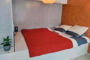 um quarto com uma cama grande e um cobertor vermelho em The Cutest Studio in Central Tampere em Tampere