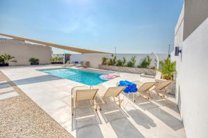 a patio with chairs and a swimming pool at Stella Stays Cozy Beachfront Villa Private Pool 4BDR in Dubai