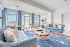 een woonkamer met twee blauwe banken en een tafel bij Stella Stays Cozy Beachfront Villa Private Pool 4BDR in Dubai