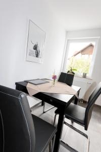 uma sala de jantar com uma mesa e cadeiras e uma janela em Ferienwohnung Naumann em Schotten