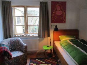 a bedroom with a bed and a chair and a window at "Lütt Huus" in Ostermarkelsdorf