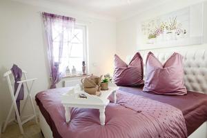 Un dormitorio con una cama con almohadas rosas y una mesa. en Les Belles, Haus Bastien, FW Galant, Whg 6 en Zingst