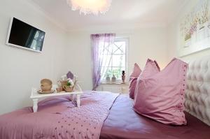 Un dormitorio con una cama rosa con una mesa encima. en Les Belles, Haus Bastien, FW Galant, Whg 6 en Zingst