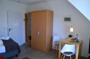 Schlafzimmer mit einem Bett, einem Tisch und einem Schrank in der Unterkunft Flurstrasse - OG links in Wyk auf Föhr