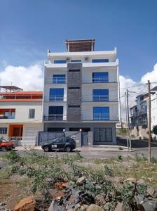 a building with a car parked in front of it at Apartamento Novo, Brand New Apartament T1, Cidadela, Praia, Cabo Verde in Praia