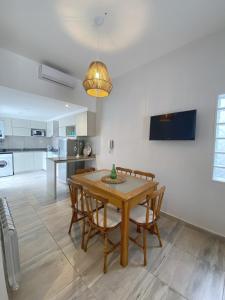 a kitchen and dining room with a wooden table and chairs at La Pedrera Apart in Villa María