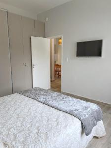 a bedroom with a bed and a flat screen tv at La Pedrera Apart in Villa María