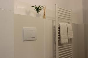 a white bathroom with a towel rack and a plant at HR RoomS in Hannover