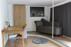 a living room with a desk and a couch at HR RoomS in Hannover +50 photos