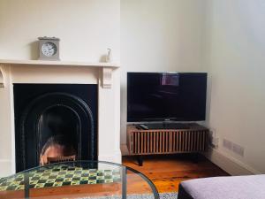 a living room with a fireplace and a tv at Cosy 2 Bedroom Reading House SLEEPS 6 - With FREE WiFi & Garden by Roost Accommodation in Reading
