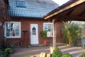 Casa de ladrillo con puerta blanca y ventanas en Ferienwohnung Biernat, en Prinzenmoor