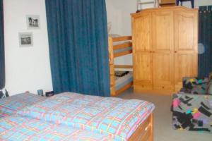 1 dormitorio con 1 cama y armario de madera en Ferienwohnung Biernat, en Prinzenmoor