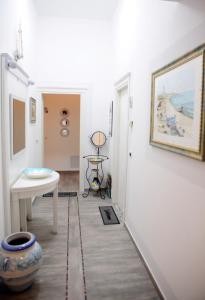 a hallway with a table and a painting on the wall at Emerella Luxury Suites-Siderno Lungomare in Siderno Marina