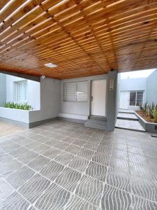 un patio vacío con techo de madera y suelo de madera en La Pedrera Apart en Villa María