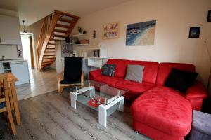 a living room with a red couch and a table at Haus am Bodden in Zingst