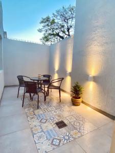 a patio with a table and chairs on a tile floor at La Pedrera Apart in Villa María