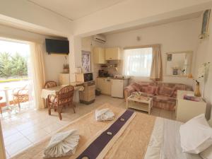 a large living room with a couch and a kitchen at Evli Apartments in Rethymno Town