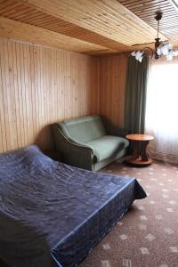 a bedroom with a bed and a chair and a window at Gutsulochka Apartment in Yaremche