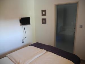 ein Schlafzimmer mit einem Bett und einem TV an der Wand in der Unterkunft PatRei mit Meerblick, auch beim Duschen in Eckernförde