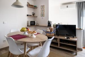 ein Esszimmer mit einem Tisch und einem TV in der Unterkunft Casa de Santa Maria in Castelo de Vide