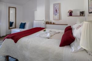 a bedroom with a large bed with red and white pillows at Casa de Santa Maria in Castelo de Vide