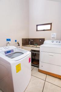 eine Waschküche mit einer Waschmaschine und einem Waschbecken in der Unterkunft Apartamento Lantana in Monteverde Costa Rica