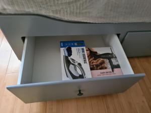 a drawer with a pair of scissors and a magazine at Cosy 1 & 2 parking et wifi gratuits in Charleroi
