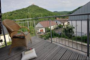 una silla sentada en una terraza con vistas a la montaña en Panorama-Fewo Töpfer, en Annweiler am Trifels