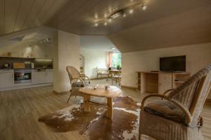 a living room with a table and chairs and a kitchen at Panorama-Fewo Töpfer in Annweiler am Trifels