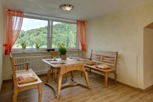 a dining room with a table and chairs and a window at Panorama-Fewo Töpfer in Annweiler am Trifels