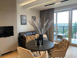 a living room with a table and a couch at Family & Business Elegant Apartments Kadzielnia, ul Zgody, Stadion Korona, WDK -1 Bedroom, Terrace, Garage - NEW! in Kielce