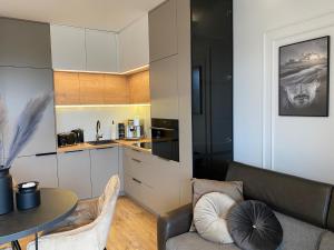 a kitchen and living room with a couch and a table at Family & Business Elegant Apartments Kadzielnia, ul Zgody, Stadion Korona, WDK -1 Bedroom, Terrace, Garage - NEW! in Kielce
