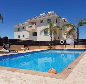 a swimming pool with a basketball in front of a building at Armstrong Apartment in Paralimni