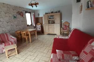 a living room with a red couch and a table at Rustic & A Chalet 'Le Sert du Grey - Vaujany in Vaujany