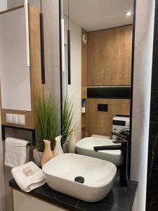 a bathroom with a white sink on a counter at Family & Business Elegant Apartments Kadzielnia, ul Zgody, Stadion Korona, WDK -1 Bedroom, Terrace, Garage - NEW! in Kielce +44 photos