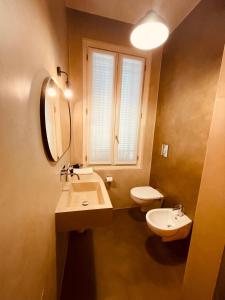 een badkamer met een wastafel, een toilet en een spiegel bij Casa Citta in Brescia