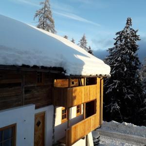 a snow covered cabin with a snow covered roof at Ringgelinhof Onach in San Lorenzo di Sebato