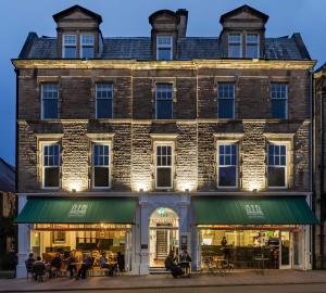 ヘクサムにあるThe Beaumont Hexhamの外に座る人々が居る大きなレンガ造りの建物