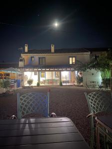 una mesa y sillas frente a una casa por la noche en Casa Chirreas, en Caravaca de la Cruz