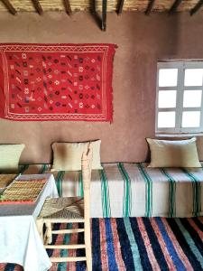 um quarto com 2 camas e uma janela em Bivouac Erg Chegaga Nomademoi em El Gouera