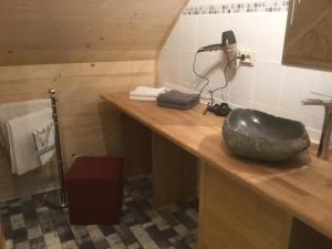 uma casa de banho com um lavatório de pedra num balcão de madeira em Ferienhaus Störzel Wohnung B em Morbach