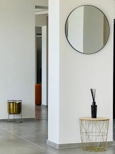 a round mirror on a wall next to a table at Hotel VIU57 in Mellieħa