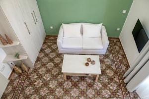 The Little big apartment in the heart of Heraklion في مدينة هيراكيلون: غرفة معيشة مع أريكة بيضاء وطاولة قهوة