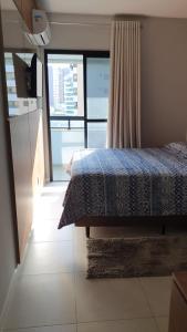 a bedroom with a bed and a large window at Apartamento Auto padrão 2 quartos vista mar praia da armação in Salvador