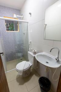 a white bathroom with a toilet and a sink at Lonier Villa Inn Economic in Abraão
