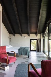 a bedroom with a bed and a couch and chairs at Agriturismo Olmo in Sondrio